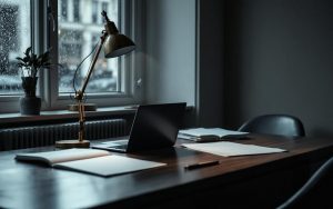 Bureau sobre et professionnel d’un cabinet de détective privé à Lille, avec une lampe de bureau, un dossier fermé, un ordinateur portable et une ambiance feutrée pour un entretien confidentiel.
