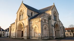 Vue extérieure paisible de la basilique Saint-Denys d’Argenteuil au matin, avec son architecture néo-romane sous un ciel clair.